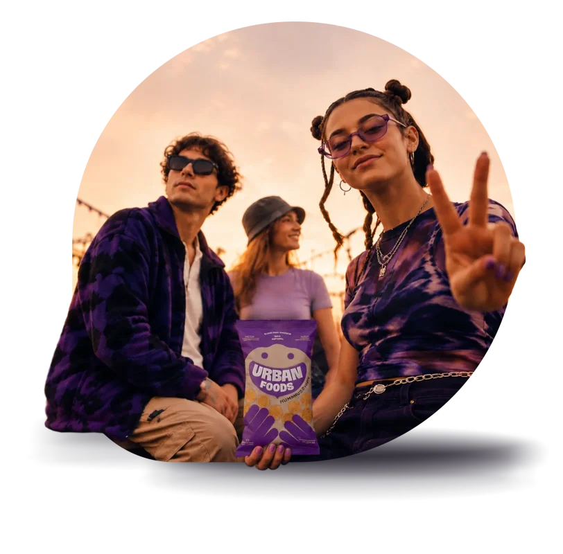 Jovens num festival ao pôr do sol com uma embalagem Urban Foods, imagem da campanha Farma Aura.
